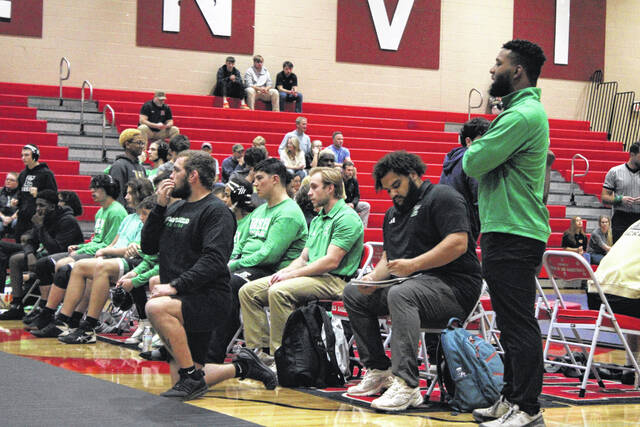Pictured is Easley wrestling coach Jordan Hawthorne (keeping the book) at a match in Greenville while his coaching staff is also glued to the action. Hawthorne is in his first season of coaching the Green Wave wrestling team.
                                 Jeff Holt | The Easley Progress